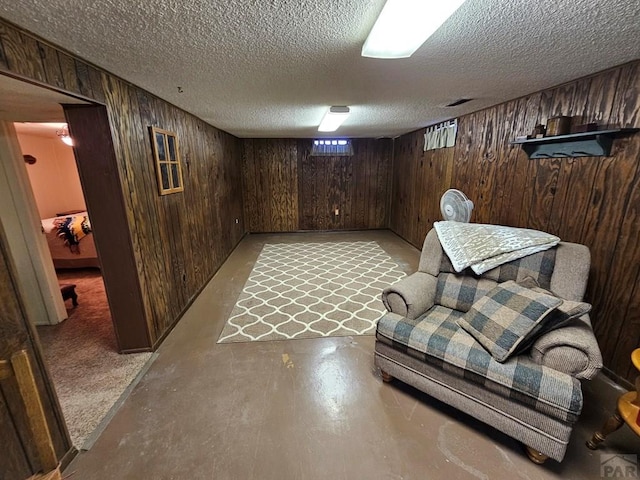 103 S Goff St, Eads, CO 81036 - living area featuring wood walls, concrete floors, and a textured ceiling