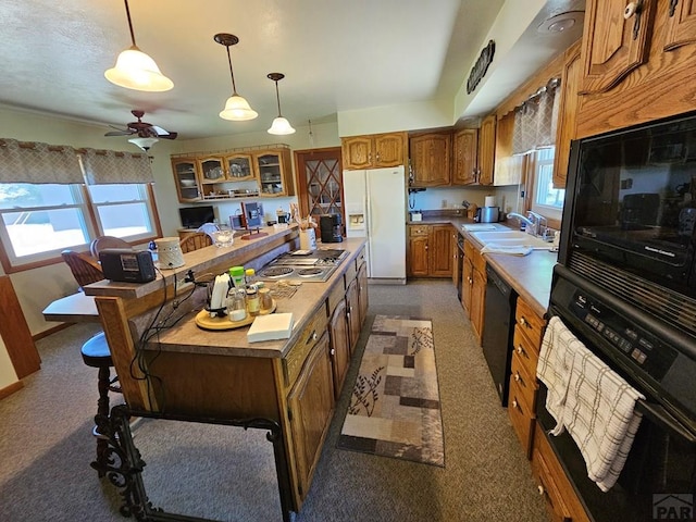 103 S Goff St, Eads, CO 81036 - kitchen with black appliances, brown cabinetry, a sink, and healthy amount of natural light