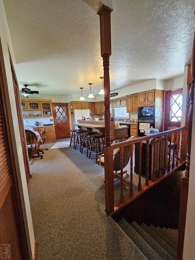 103 S Goff St, Eads, CO 81036 - living area featuring light colored carpet, a textured ceiling, and a ceiling fan