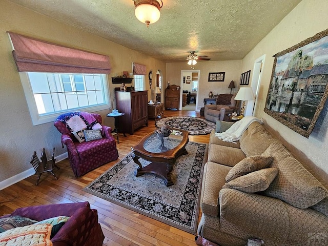 103 S Goff St, Eads, CO 81036 - living area featuring a textured ceiling, wood-type flooring, ceiling fan, a textured wall, and baseboards
