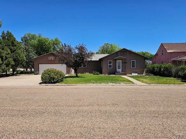 103 S Goff St, Eads, CO 81036 - view of front of home with a front yard, stucco siding, concrete driveway, and an attached garage