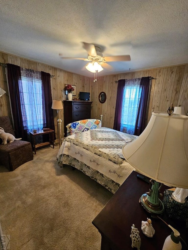 103 S Goff St, Eads, CO 81036 - carpeted bedroom featuring wooden walls, a textured ceiling, and a ceiling fan