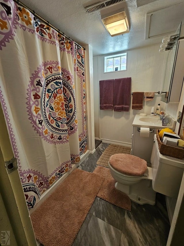 103 S Goff St, Eads, CO 81036 - bathroom featuring toilet, a textured ceiling, vanity, baseboards, and curtained shower