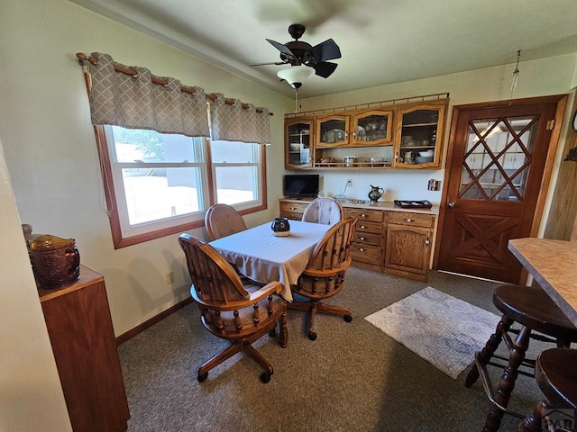 103 S Goff St, Eads, CO 81036 - dining space featuring dark colored carpet, a ceiling fan, and baseboards