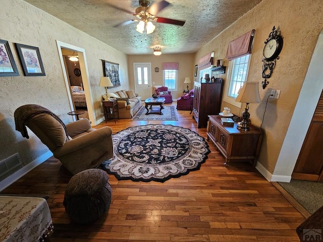 103 S Goff St, Eads, CO 81036 - living room with a textured wall, wood-type flooring, a ceiling fan, a textured ceiling, and baseboards
