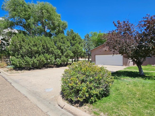 103 S Goff St, Eads, CO 81036 - view of side of home with stucco siding, a lawn, and a garage