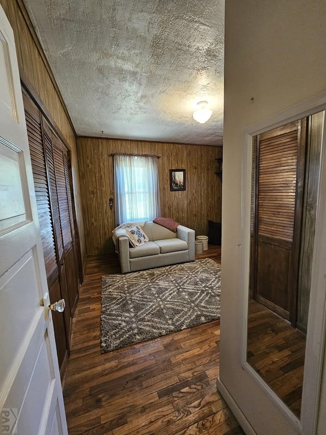 103 S Goff St, Eads, CO 81036 - living room with dark wood-type flooring, wood walls, and a textured ceiling