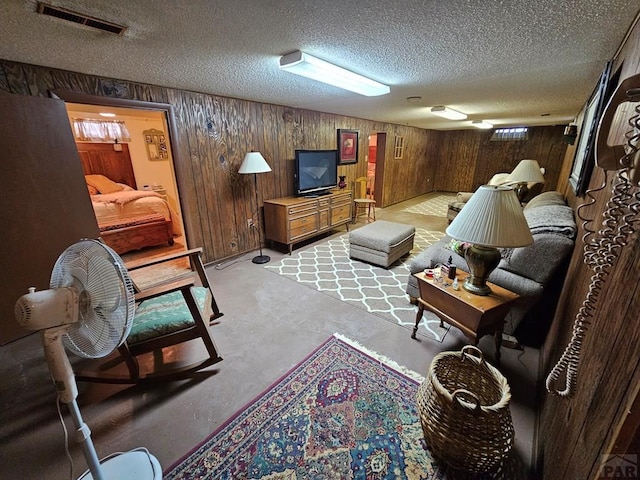 103 S Goff St, Eads, CO 81036 - living area featuring concrete flooring, wooden walls, and a textured ceiling