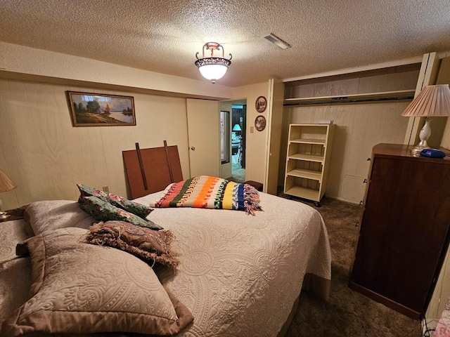 103 S Goff St, Eads, CO 81036 - bedroom featuring carpet floors, wood walls, and a textured ceiling