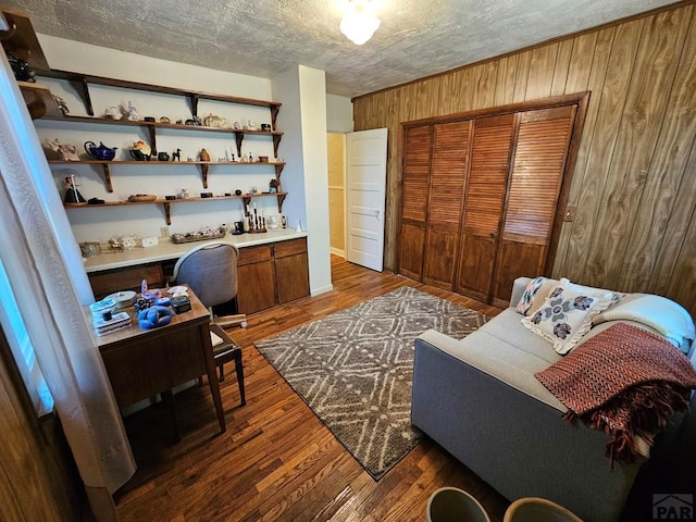 103 S Goff St, Eads, CO 81036 - office area with wood walls, wood finished floors, and a textured ceiling