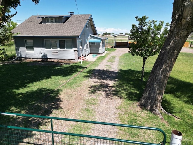 exterior space with a shingled roof, fence, and dirt driveway