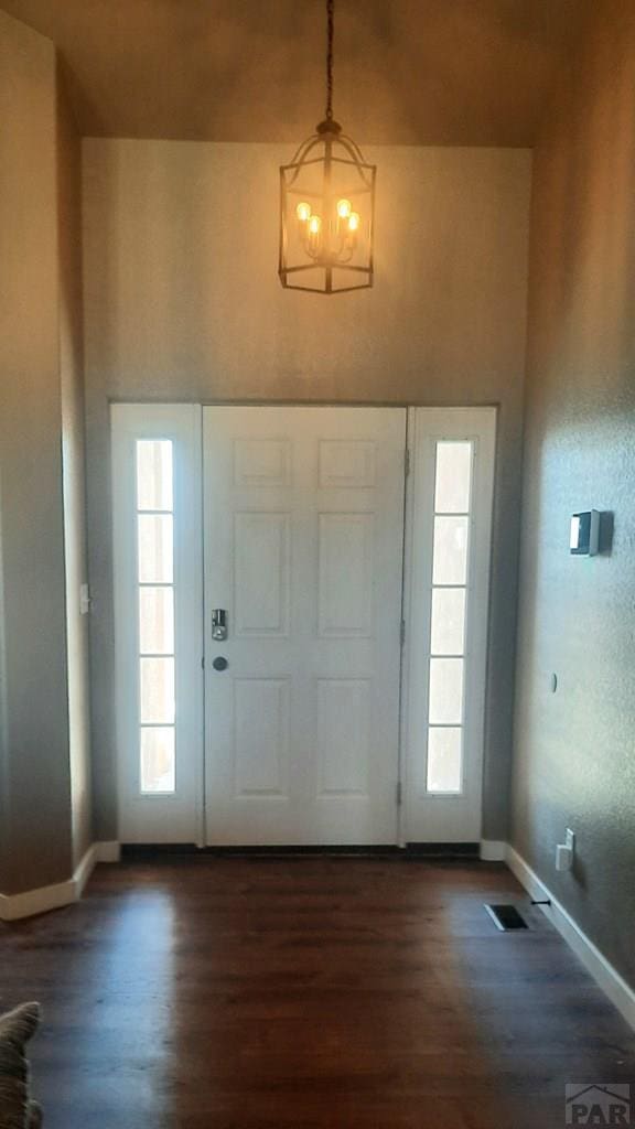 foyer entrance featuring wood finished floors, visible vents, plenty of natural light, and baseboards