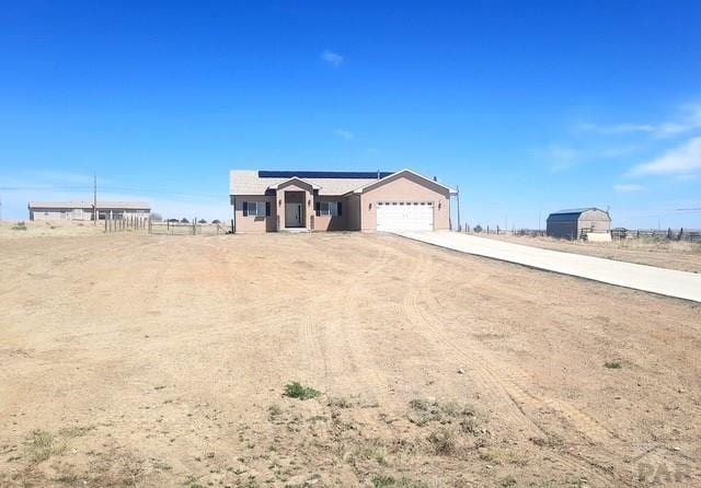 view of front of property with solar panels, concrete driveway, and an attached garage
