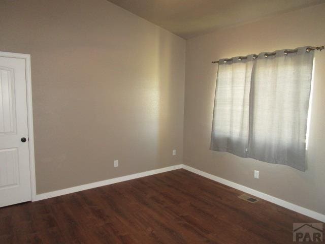 spare room featuring visible vents, wood finished floors, and baseboards
