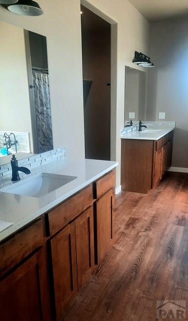 bathroom featuring vanity, wood finished floors, and baseboards