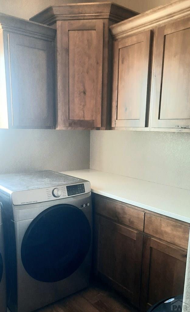 laundry room featuring cabinet space, dark wood-type flooring, and washer / clothes dryer