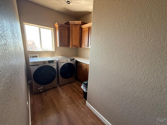 1710 N Wild Bill Hickock Dr, Pueblo West, CO 81007 - laundry area with cabinet space, dark wood-style flooring, a textured wall, and washing machine and dryer