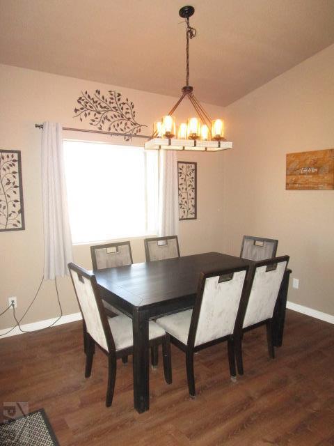 dining room with a chandelier, baseboards, and dark wood finished floors