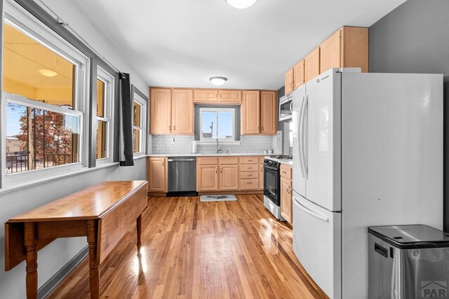 2701 Franklin Ave, Pueblo, CO 81003 - kitchen with stainless steel appliances, light brown cabinets, light wood-type flooring, light countertops, and backsplash
