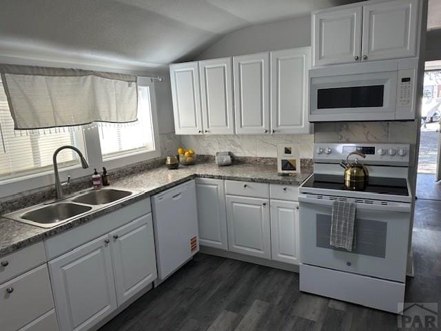 715 E 7th St, Pueblo, CO 81001 - kitchen featuring white appliances, a sink, vaulted ceiling, white cabinetry, and dark wood-style flooring