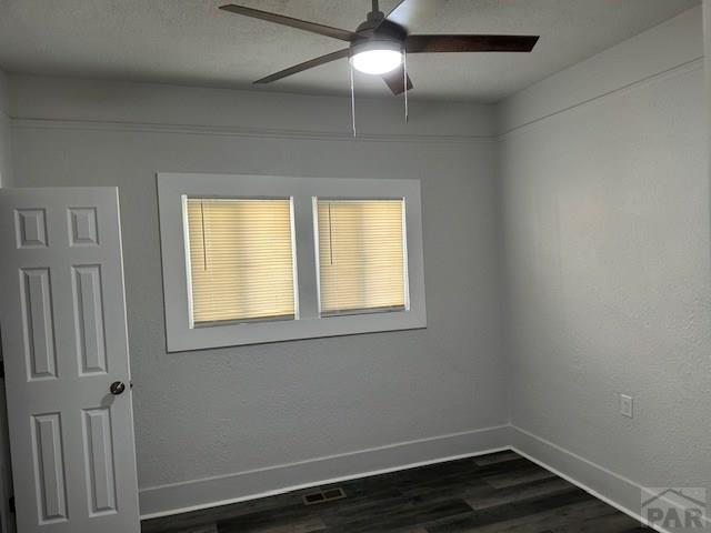 715 E 7th St, Pueblo, CO 81001 - unfurnished room with dark wood-style floors, baseboards, and ceiling fan