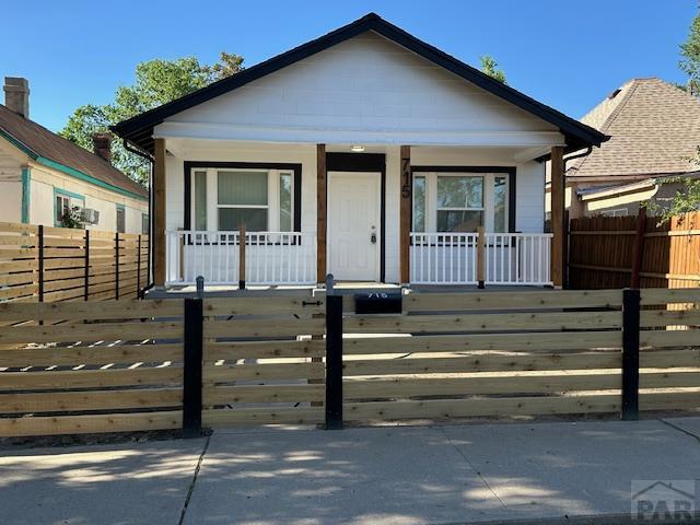 715 E 7th St, Pueblo, CO 81001 - view of front of house featuring covered porch and a fenced front yard