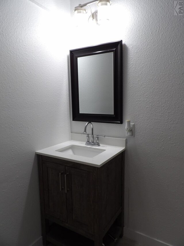 bathroom featuring a textured wall and vanity