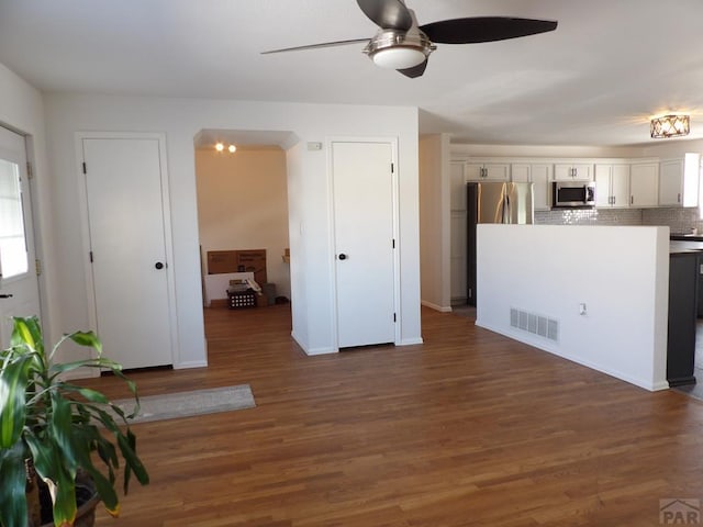 kitchen with visible vents, white cabinets, dark wood-style flooring, stainless steel appliances, and light countertops