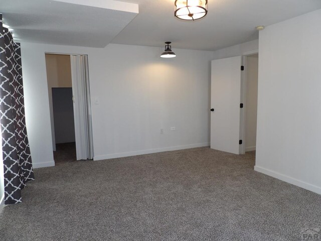 carpeted empty room with baseboards