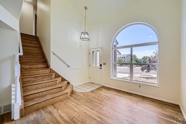 4366 Witches Hollow Ln, Colorado Springs, CO 80911 - foyer with high vaulted ceiling, stairway, and wood finished floors
