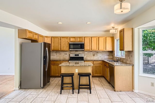 4366 Witches Hollow Ln, Colorado Springs, CO 80911 - kitchen featuring stainless steel appliances, a center island, tasteful backsplash, light stone countertops, and recessed lighting