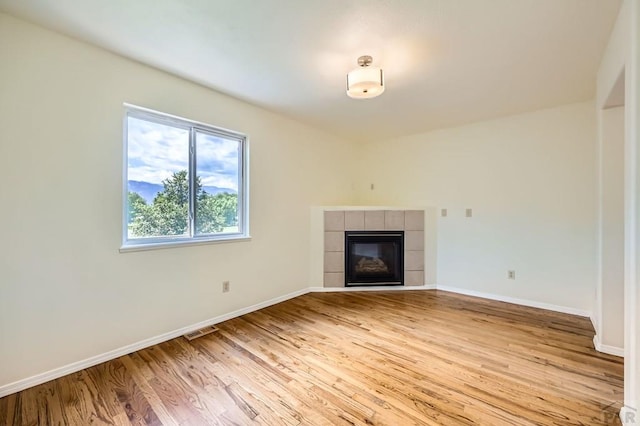 4366 Witches Hollow Ln, Colorado Springs, CO 80911 - unfurnished living room featuring light wood-style floors and a fireplace