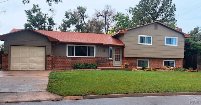 29 Mountview Dr, La Junta, CO 81050 - tri-level home with an attached garage, brick siding, a front lawn, concrete driveway, and a chimney