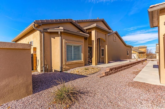 rear view of property with stucco siding and a patio