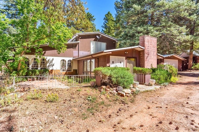 mid-century inspired home featuring fence and an attached garage