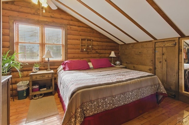 bedroom with rustic walls, lofted ceiling, and hardwood / wood-style flooring