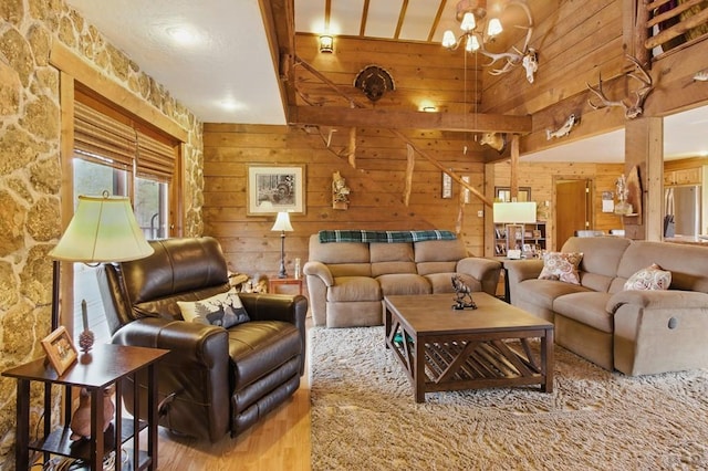 living area featuring wood finished floors, wood walls, and an inviting chandelier