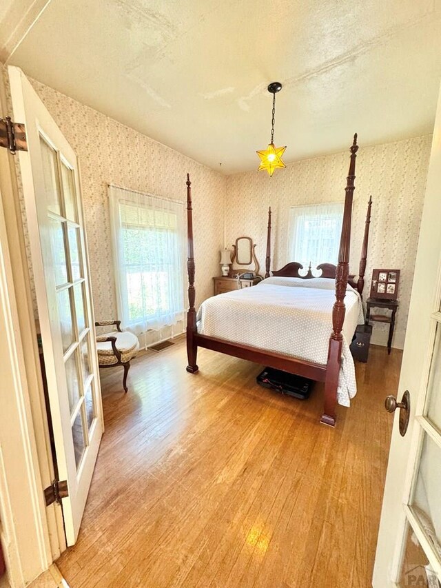 914 Santa Fe, La Junta, CO 81050 - bedroom with wallpapered walls, light wood finished floors, and multiple windows