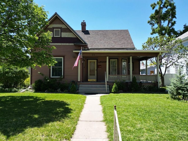 914 Santa Fe, La Junta, CO 81050 - view of front of home featuring a porch, a front yard, roof with shingles, and a chimney
