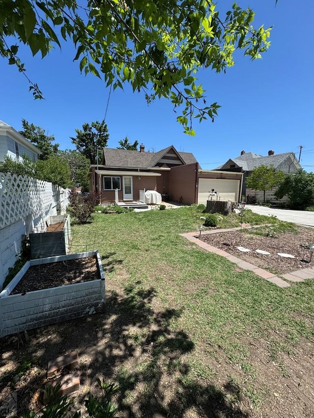 914 Santa Fe, La Junta, CO 81050 - view of front of house with a vegetable garden, driveway, and an attached garage