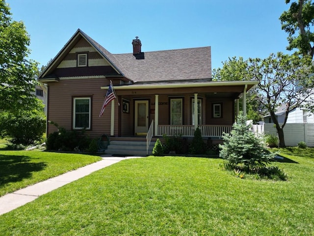 914 Santa Fe, La Junta, CO 81050 - victorian home with roof with shingles, a porch, a chimney, and a front lawn
