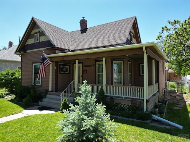 914 Santa Fe, La Junta, CO 81050 - view of front of home with a porch, a front lawn, a chimney, and roof with shingles