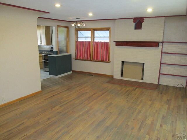 unfurnished living room featuring ornamental molding, dark wood finished floors, and a fireplace