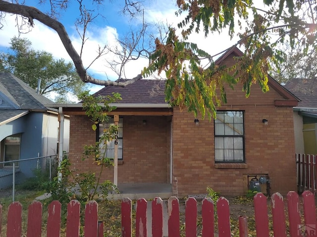 view of side of property with a fenced front yard and brick siding