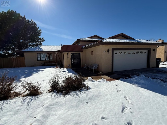 single story home featuring a garage, a tile roof, fence, and stucco siding