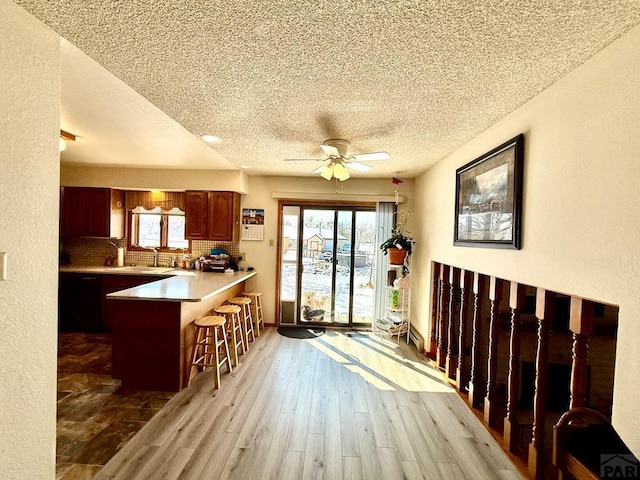 interior space with a textured ceiling, plenty of natural light, a sink, and light wood-style flooring