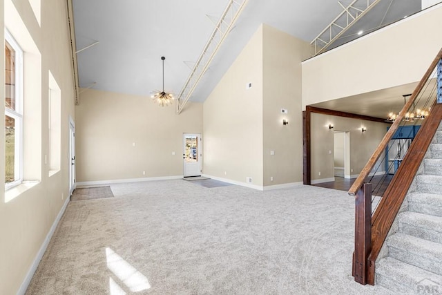 332 Yellow Bird Rd, Rye, CO 81069 - unfurnished living room with a towering ceiling, carpet flooring, stairway, and a chandelier