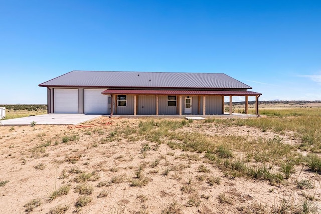 332 Yellow Bird Rd, Rye, CO 81069 - farmhouse featuring concrete driveway, an attached garage, a metal roof, and covered porch