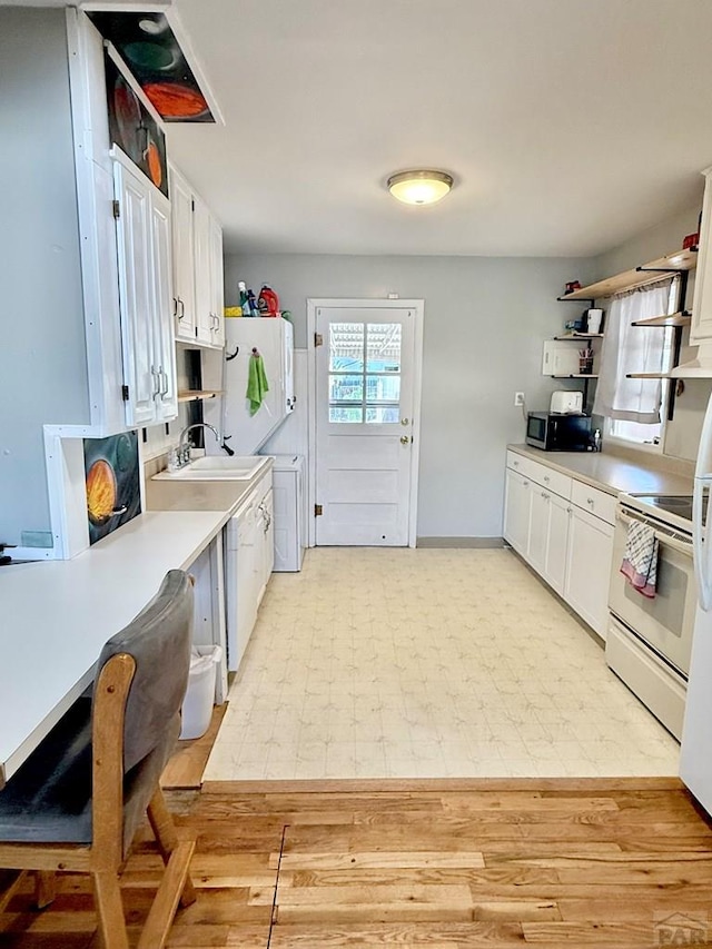 629 Gaylord Ave, Pueblo, CO 81004 - kitchen with white range with electric cooktop, open shelves, white cabinetry, light countertops, and stainless steel microwave