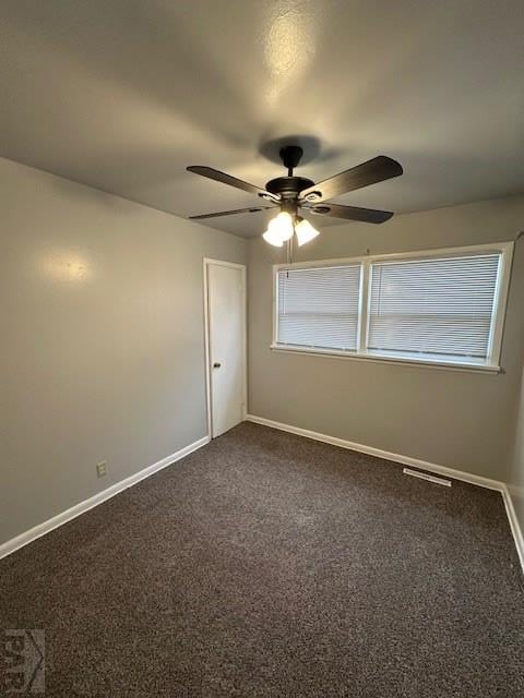 empty room with baseboards, dark colored carpet, ceiling fan, and plenty of natural light